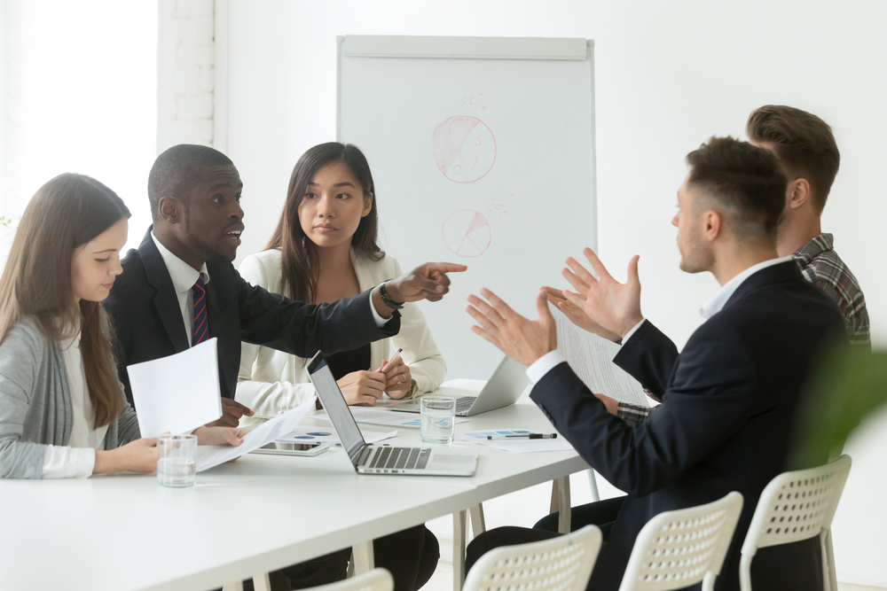Effects of Workplace Discrimination on Employees - Diverse employees arguing during team meeting, african office worker disagreeing with caucasian colleague, black and white businessmen disputing at negotiations, multiracial conflict at work concept