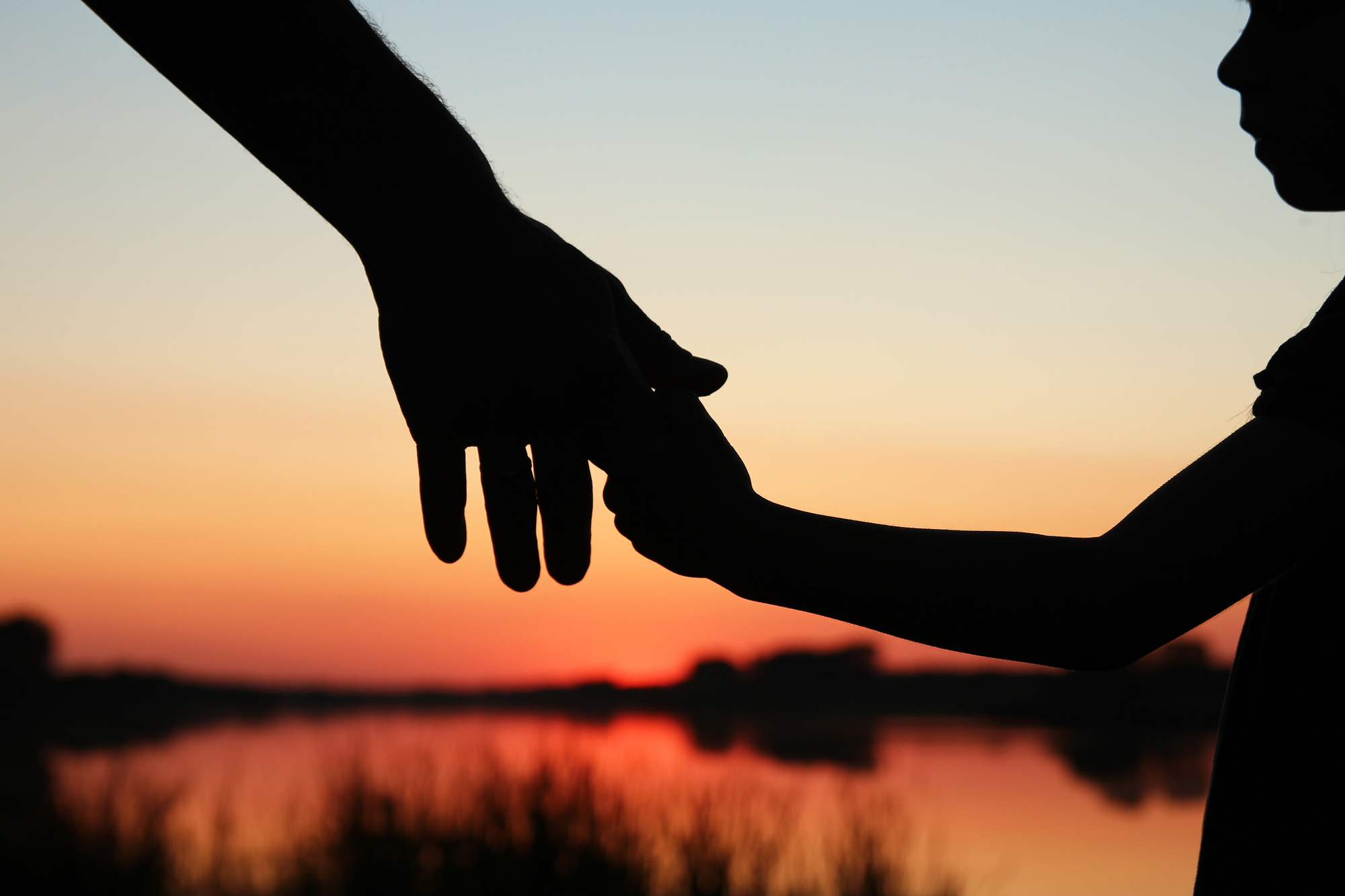FMLA and PDA: What Rights Do You Have as a Working Pregnant Woman? - silhouette parent and child hands